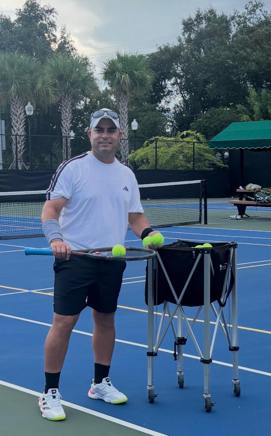 Coach Eddy en la cancha con su carro de pelotas